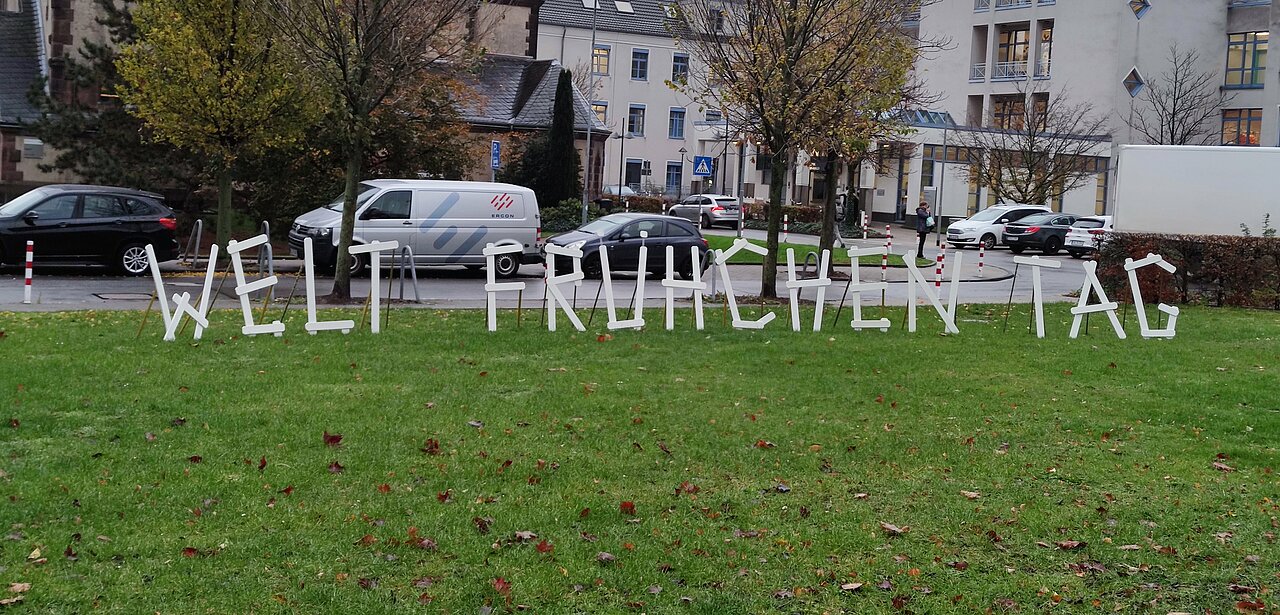 Große weiße Buchstaben "Weltfrühchentag" auf einer Wiese