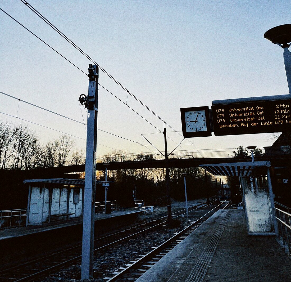 Zu sehen ist eine Bahnhaltestelle in Lohhausen und eine Tafel auf der die nächste Fahrt Richtung Uni Ost/Botanischer Garten angeschlagen ist.