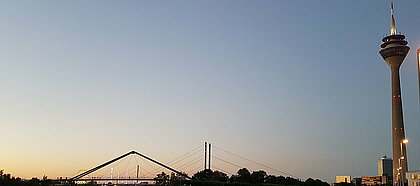 Zu sehen is der Rheinturm bei Sonneuntergang