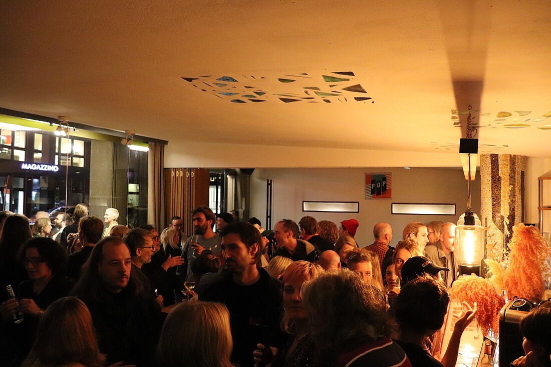 Zu sehen sind viele Gäste der Preisverleihung, die vor der Veranstaltung an der Bar im Foyer des Gloria Köln stehen.