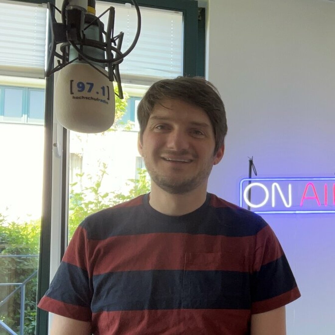 Auf dem Bild sitzt Björn Siebke neben einem Mikrofon zu sehen.