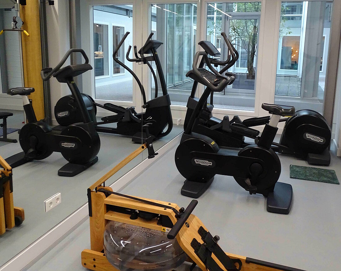 Auf dem Foto ist das Fitnessstudio mit einigen Fitnessgeräten zu sehen.