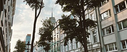 Es ist eine Straße in Unterbilk und im Hintergrund der Rheinturm zu sehen. 