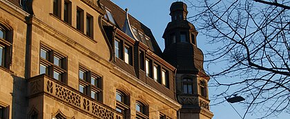 Auf dem Bild sieht man ein älteres Gebäude in Düsseldorf, das von der nachmittags Sonne in orangenes Licht getaucht wird (Foto: Michelle Pieczyk)