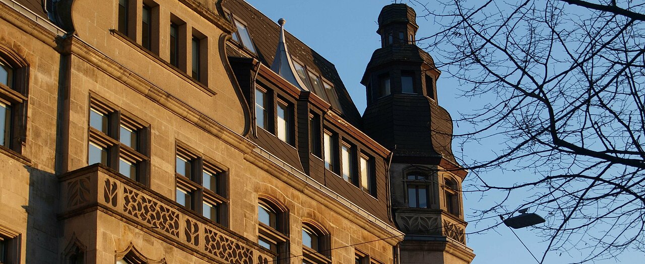 Auf dem Bild sieht man ein älteres Gebäude in Düsseldorf, das von der nachmittags Sonne in orangenes Licht getaucht wird (Foto: Michelle Pieczyk)