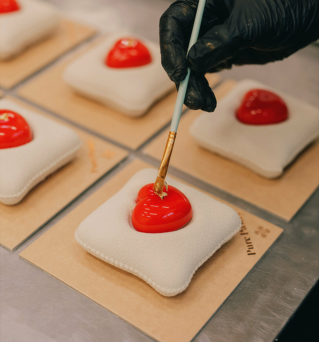 Person platziert Blattgold auf einem Dessert