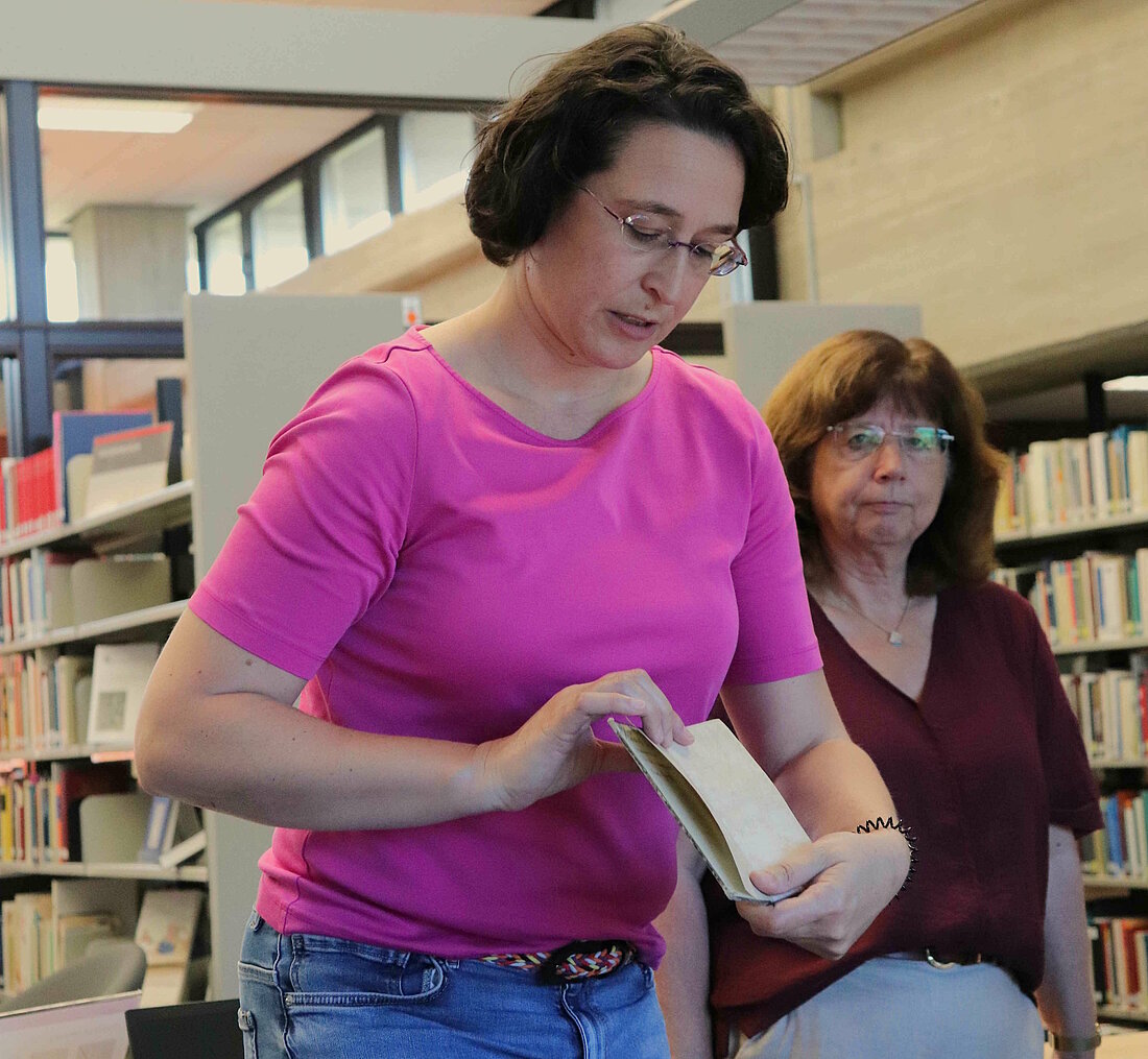 Zu sehen sind die beiden Projektleiterinnen Filomena Lopedoto und Dr. Ute Olliges-Wieczorek. Lopedoto hält ein Buch in der Hand.
