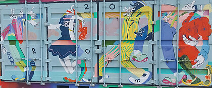 Auf dem Bild ist ein Container zu sehen, der vollständig mit einem bunten Graffiti bemalt. Das Graffiti zeigt vier hintereinander tanzende Menschen in Comic Stil. 