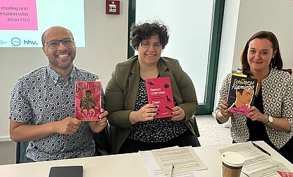 Auf dem Foto sind von links nach rechts, Autor Dean Atta, Dr. Bettina Burger und Dr. Hannah Pardey mit der englischen Ausgabe von Der Schwarze Flamingo zu sehen.