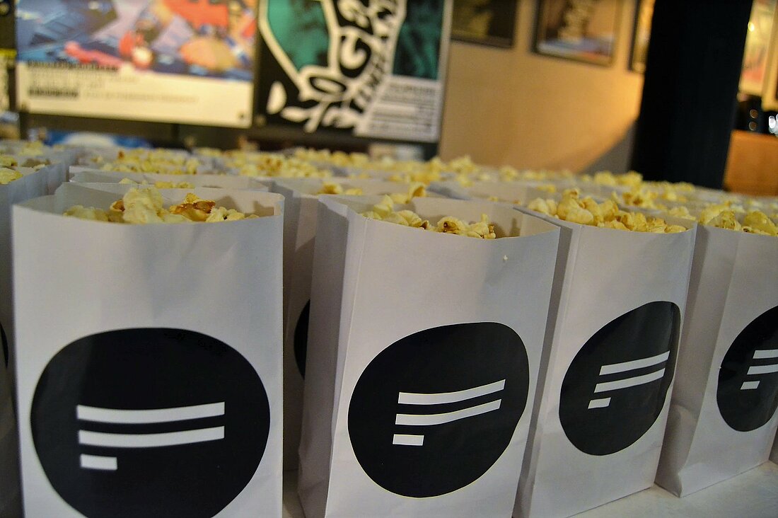 Zu sehen sind nebeneinander gereihte Popcorntüten mit dem Logo des Filmfestes Düsseldorf. 