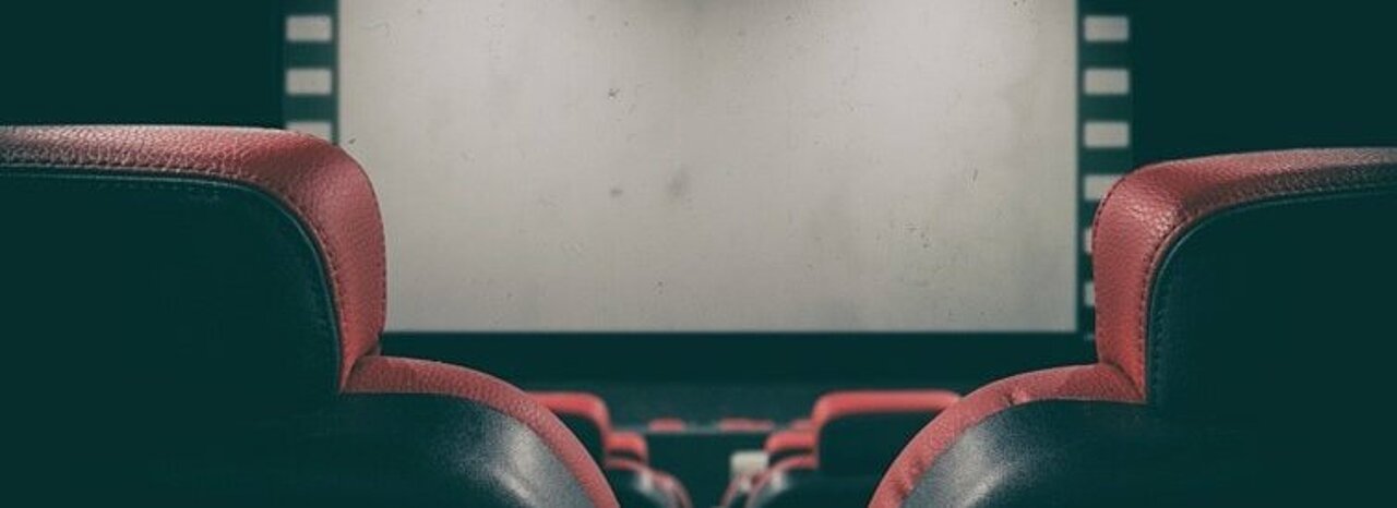 Kinosaal mit roten Sitzen.