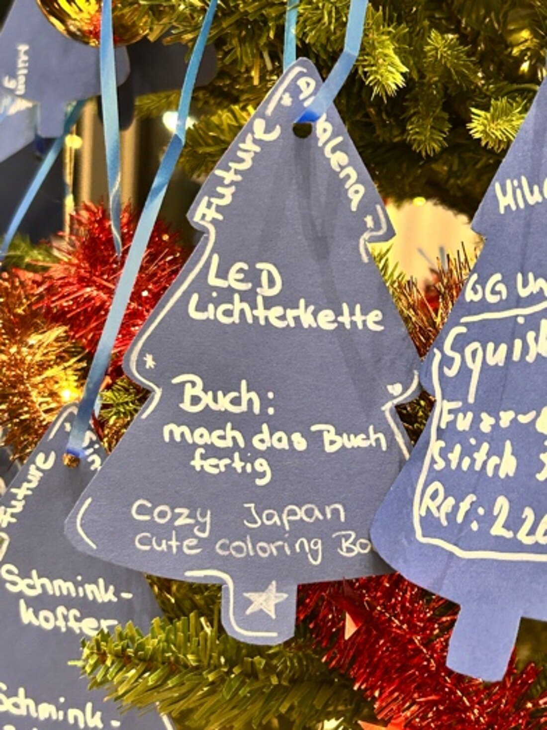 Man sieht die Wunschzettel des Wunschbaums in Nahaufnahme.