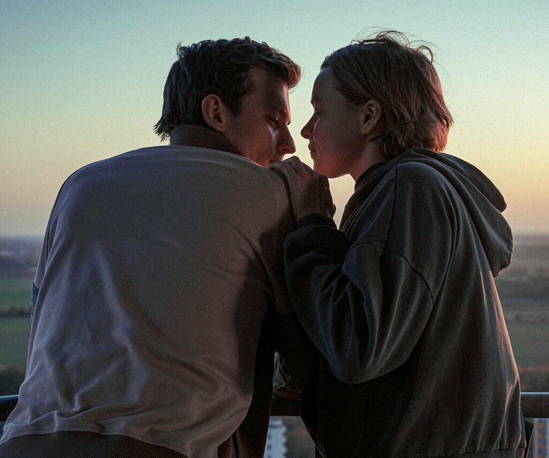 Man sieht die Filmfiguren Tilda und Viktor, wie sie auf einem Hausdach stehen und sich verträumt in die Augen schauen