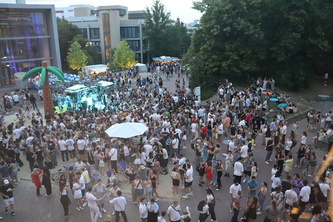 Man sieht aus der Vogelperspektive die Besucher:innen der Party auf dem Campus.