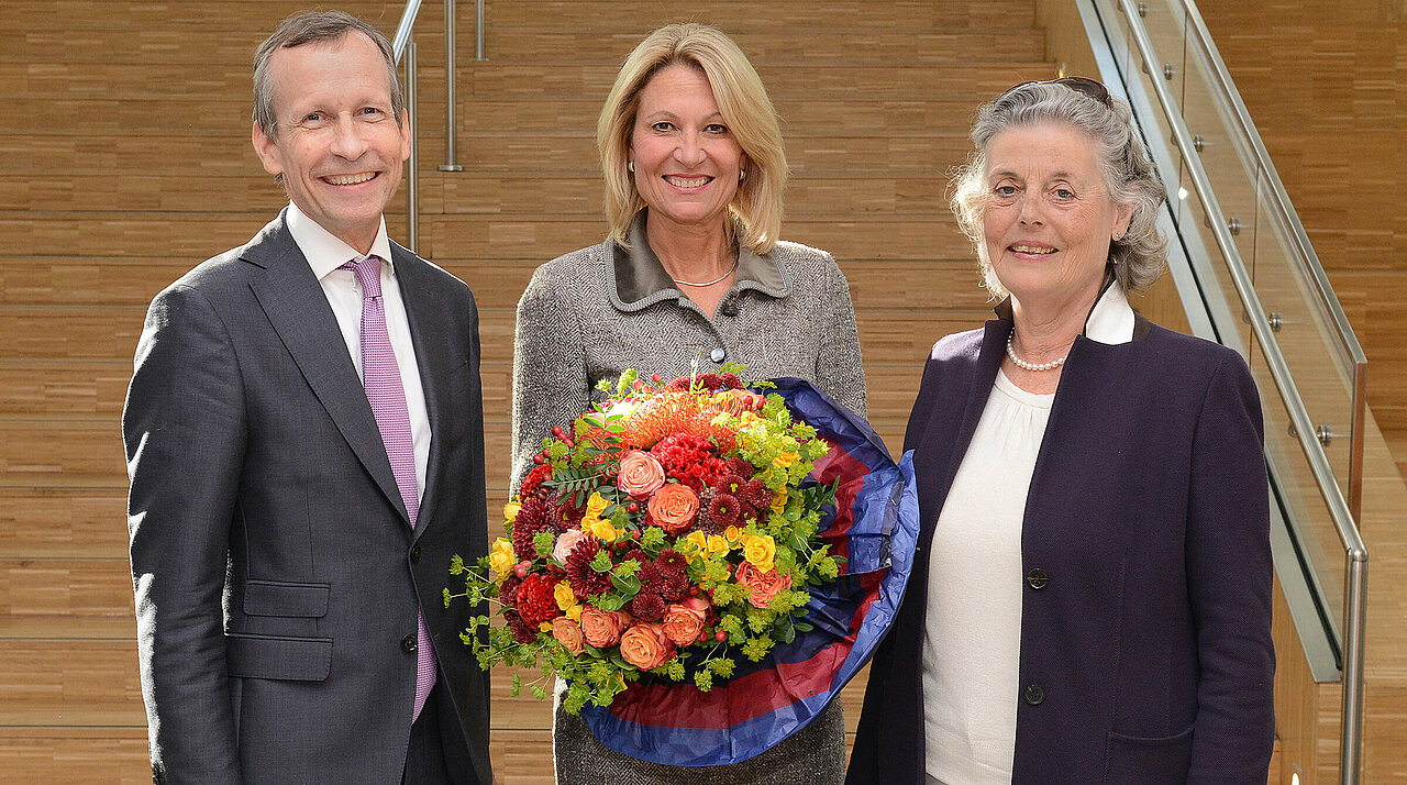 Die Rektorin Prof. Dr. Anja Steinbeck mit dem Senatsvorsitzenden Prof. Dr. Wolfram Trudo Knoefel und der Hochschulratsvorsitzenden Anne-José Paulsen. (Foto: HHU/Judith Michaelis) Ein Herr im Anzug und zwei Damen, die ebenfalls schick angezogen sind, lächeln in die Kamera