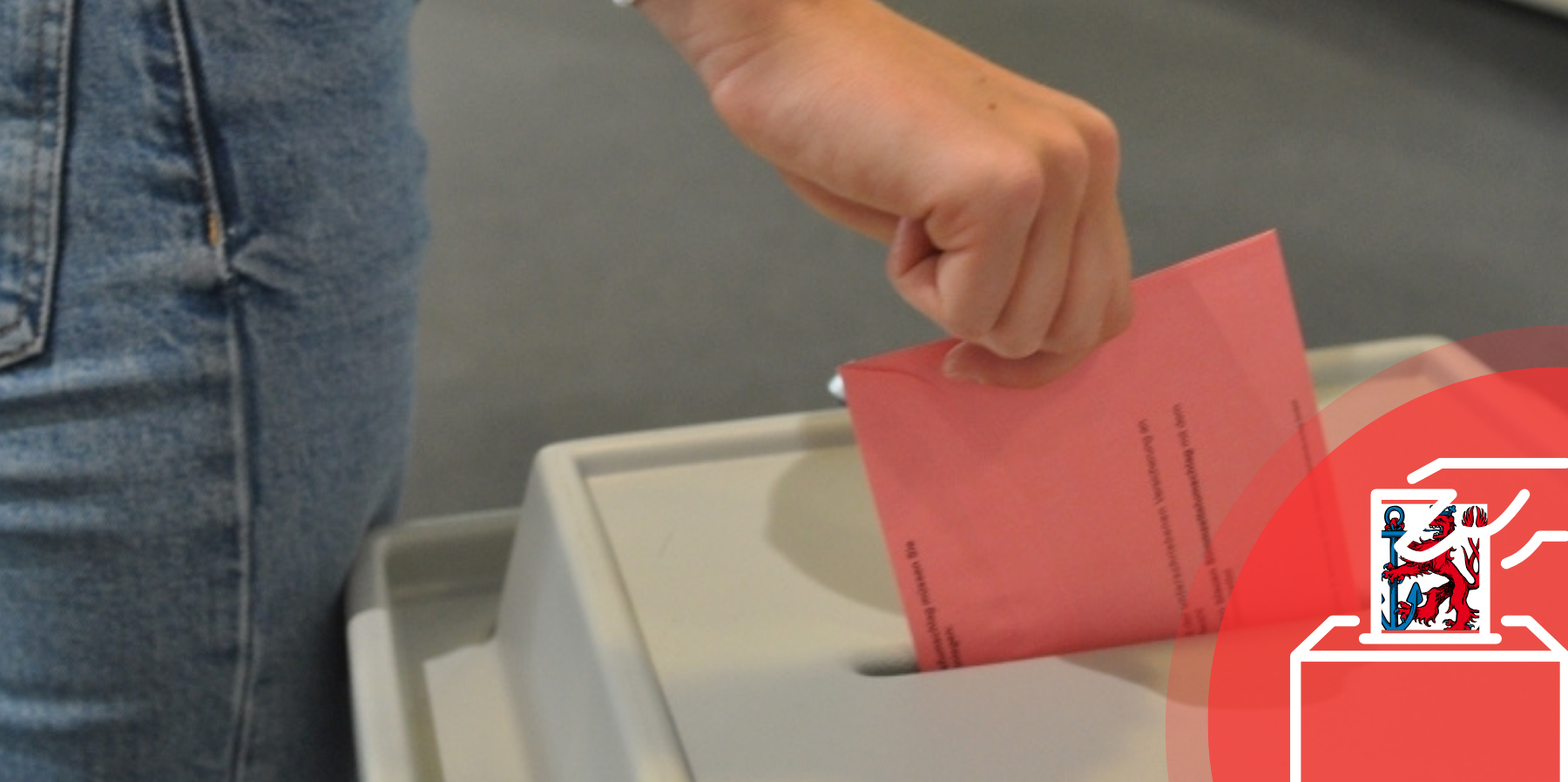 Auf dem Foto ist eine Hand zu sehen, die einen Wahlzettel in eine Wahlurne wirft.