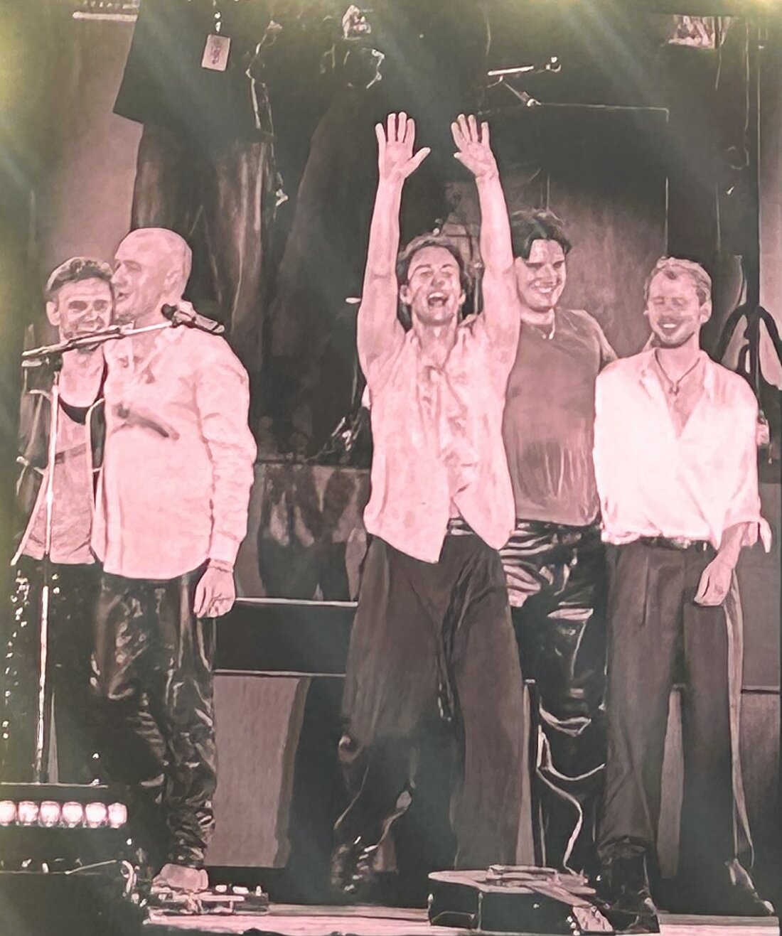 Die Bandmitglieder sind auf einer Leinwand zu sehen, wie sie sich nach dem Konzert verabschieden.