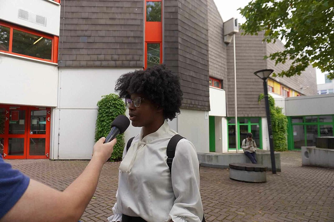 Auf dem Bild sieht man die Studentin Comoe Yael Oriane Yao, die von hochschulradio düsseldorf interviewt wird (Foto: Katie Hamed)