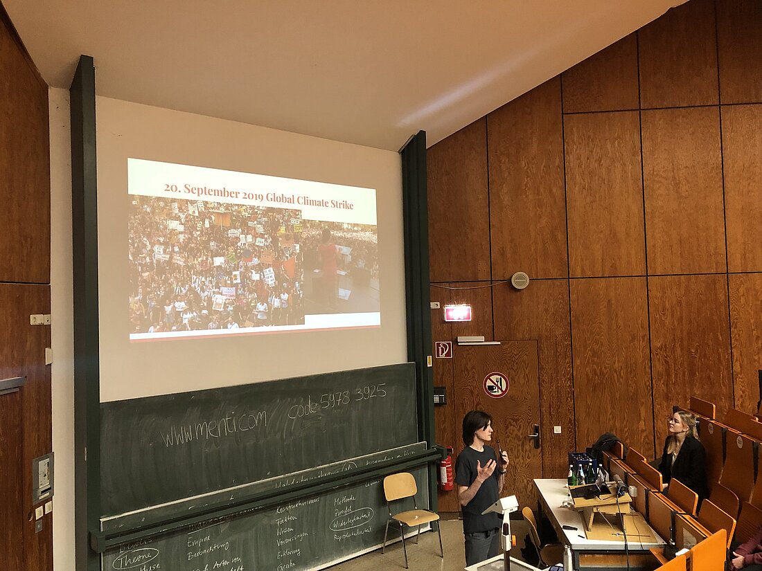 Der zweite Slam des Abends. (Foto: Valeska Ridzewski) Auf der Folie zum Slam ist ein Bild des internationalen "Climate Strike"