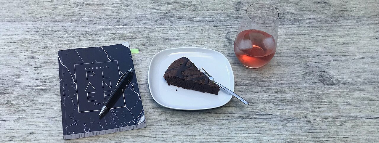 Abgebildet sind von links nach rechts ein Semesterplaner, ein Stück Kuchen und ein gekühltes Getränk.