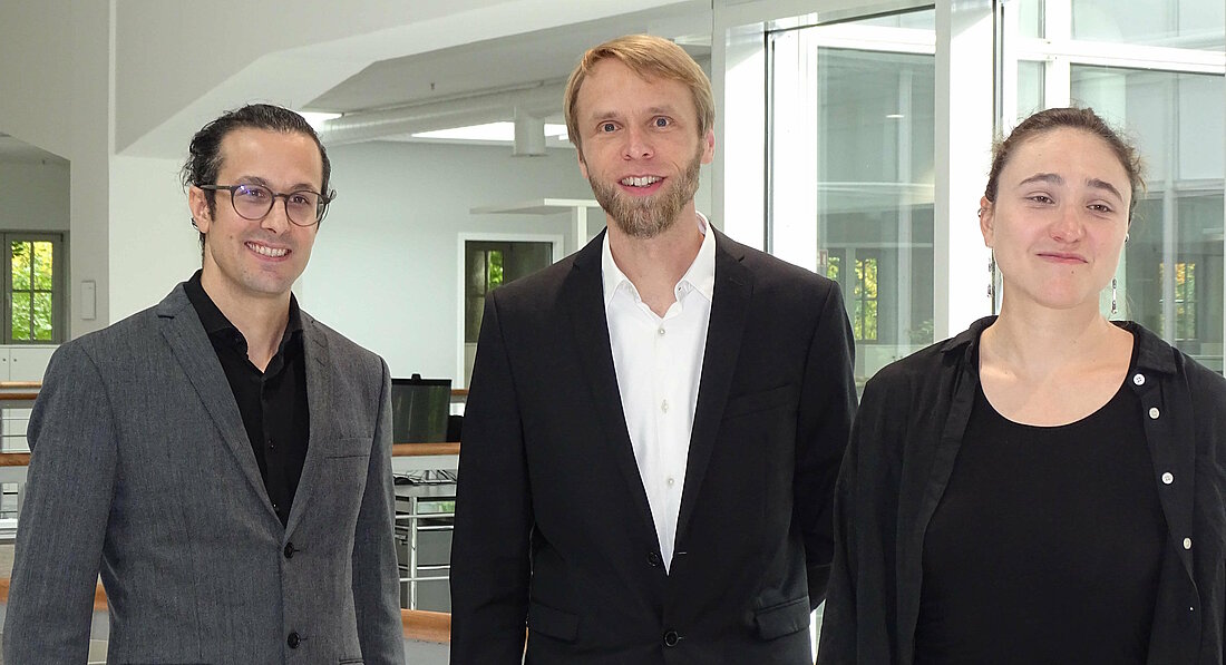 Auf dem Foto sind die Wissenschaftler:innen  Jun.-Prof. Daniel Dörr,  Prof. Tobias Marshall und Jun.-Prof. Nora Tabea Sibert zu sehen. Sie stehen in einer Reihe und lächeln in die Kamera. 
