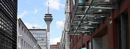 Der Rheinturm in Düsseldorf und Gebäude im Medienhafen.