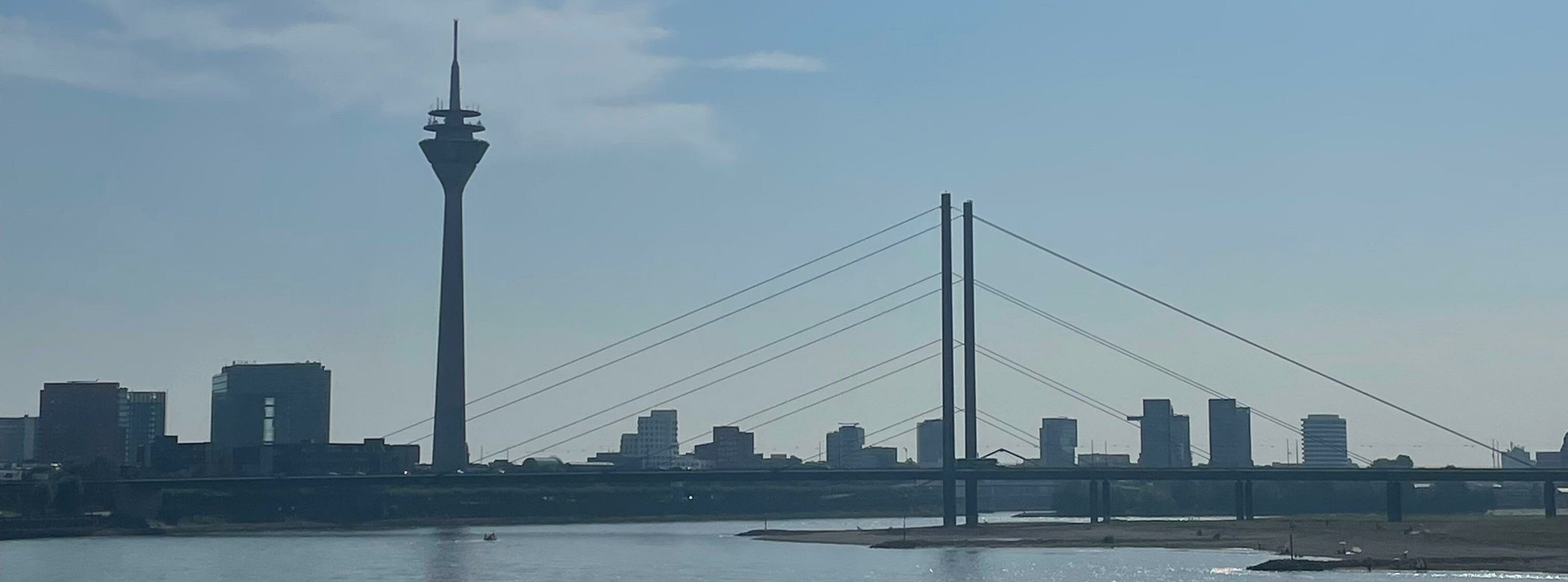 Auf dem Foto ist der Rhein und der Fernsehturm an einem sonnigen Tag zu sehen