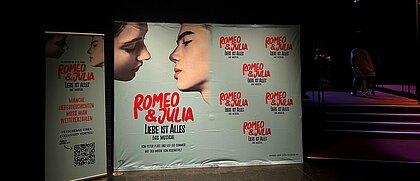 Man sieht einen Aufsteller mit dem Poster und Titel des Musicals "Romeo und Julia".