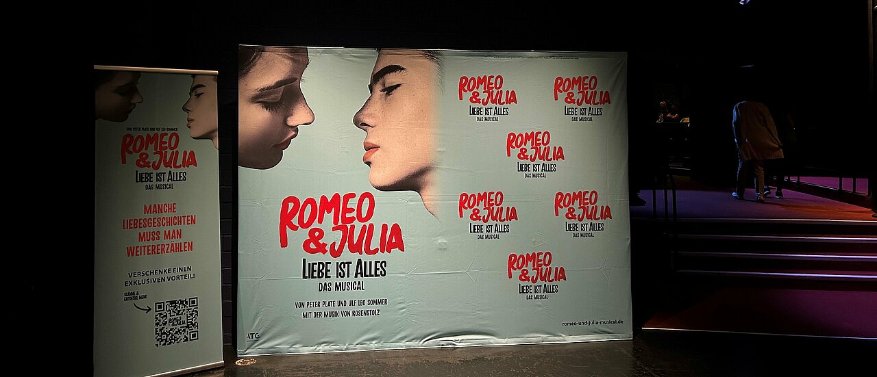 Man sieht einen Aufsteller mit dem Poster und Titel des Musicals "Romeo und Julia".