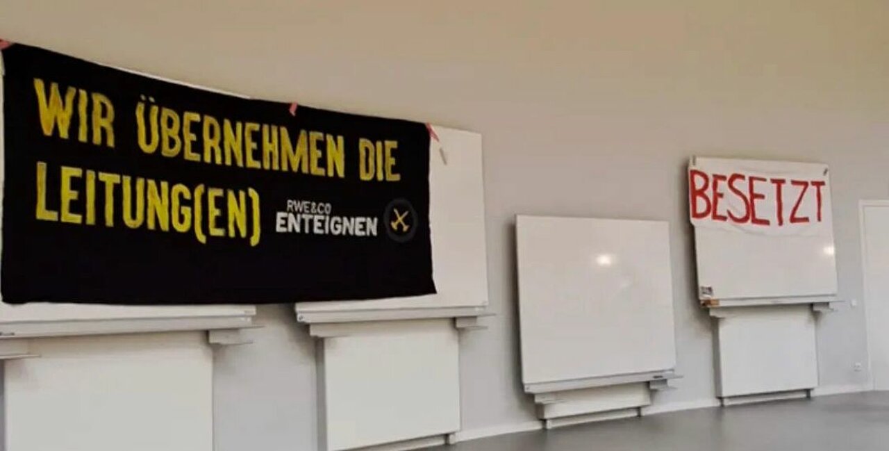 Die Besetzer:innen haben einen Banner mit der Aufschrift "Besetzt" im Hörsaal aufgehangen.