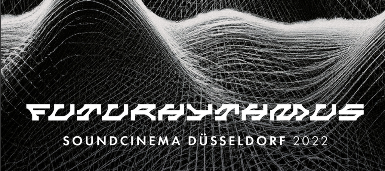 Das offizielle Plakat zum Soundcinema Düsseldorf 2022.(Foto: Soundcinema Düsseldorf/Sonische Inteferrenzen e.V.) Man sieht ein schwarzes Plakat auf dem in weißen, verzerrten Buchstaben die Aufschrift „Futurhythmus“ steht. Über der Aufschrift sind mehrere Darstellungen von Tonwellen zu sehen.
