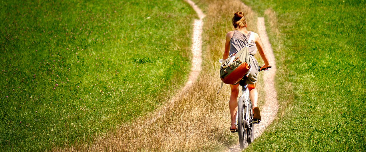 Nicht nur gut fürs Klima, auch gut für die Gesundheit(Foto: fietzfotos/pixabay) Frau auf dem Fahrrad, fährt über einen Feldweg