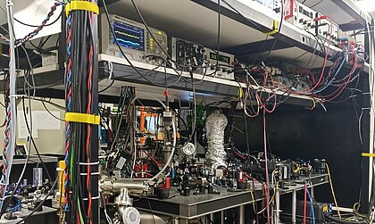 Aufbau des Experimenttisches: mehrere Ebenen mit Messgeräten, vielen Spiegeln, Kabeln und Lasern (Foto: Anastassija Sheremet) Aufbau des Experimenttisches: mehrere Ebenen mit Messgeräten, vielen Spiegeln, Kabeln und Lasern