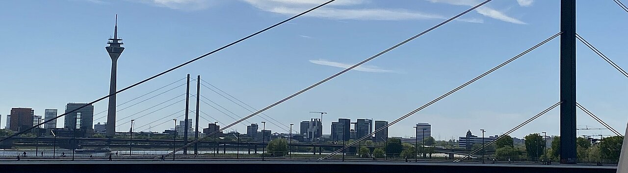 Auf dem Bild sieht man die Skyline von Düsseldorf bei Tag mit der Rheinkniebrücke und dem Fernsehturm