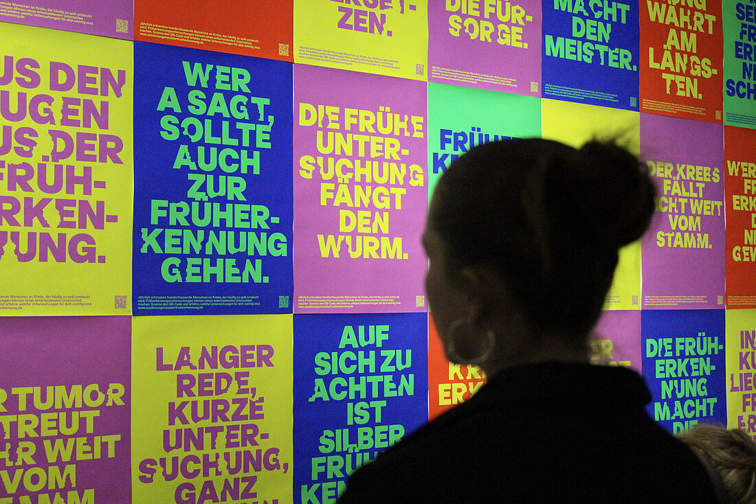 Eine Silhouette stehe vor einer bunten Plakatwand