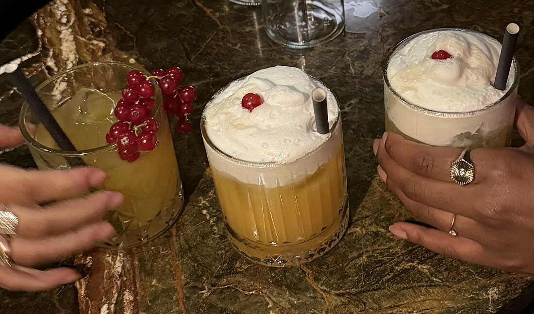 Auf dem Foto sieht man zwei Hände, die Mocktails halten.