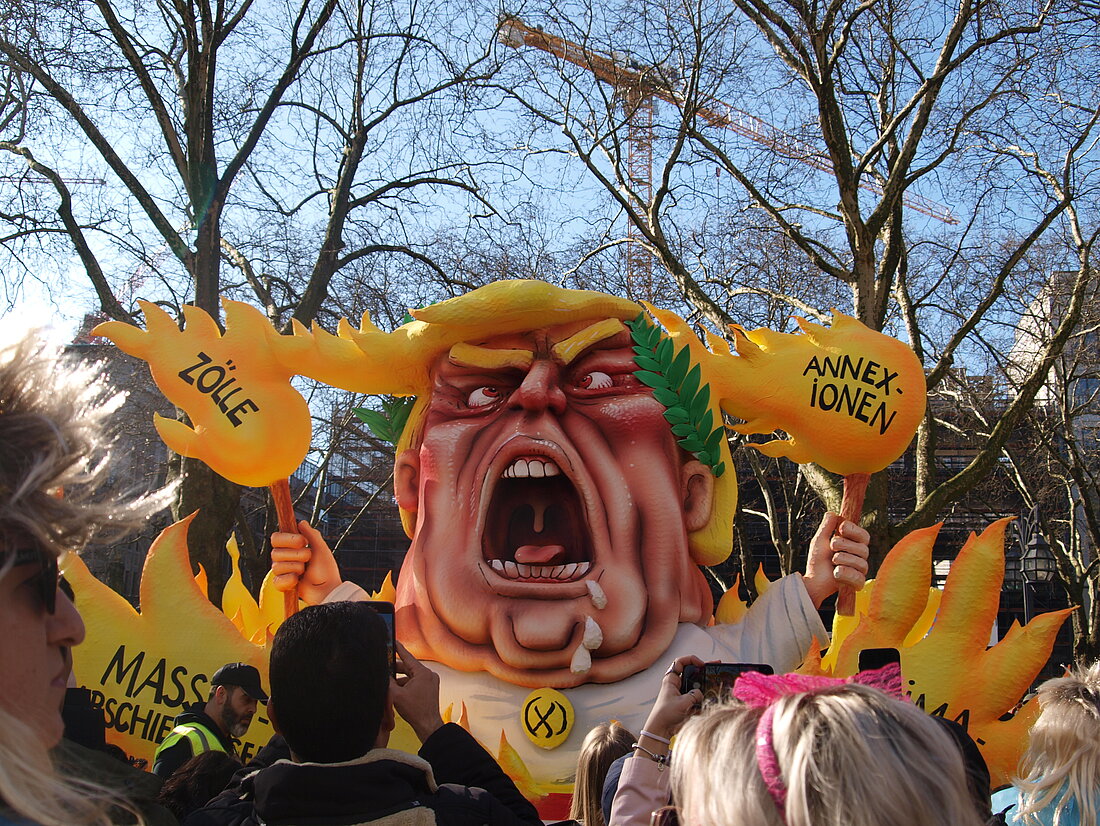 Ein Trump-Mottowagen, wo Trump in Flammen steht mit seinen Annexionen, Zöllen, Klimazerstörung und Massenabschiebungen. 