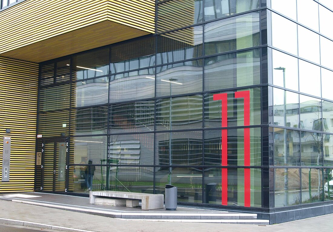 Ein Gebäude mit Glasfront und der Zahl 11 in rot drauf.