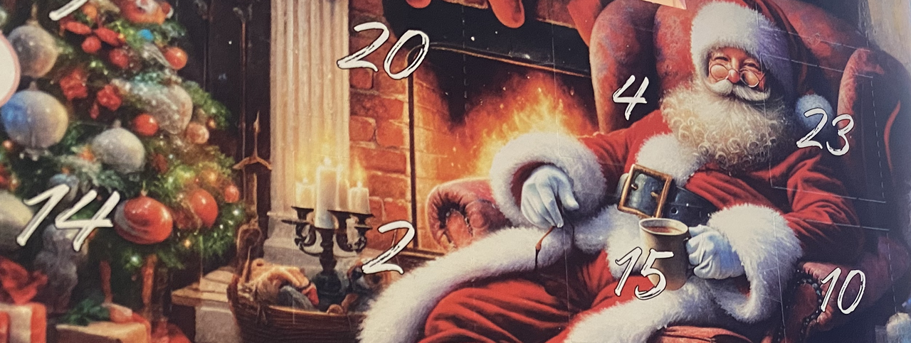 Man sieht einen Adventskalender, der in grünen Tannenzweigen steht.