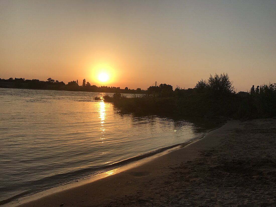 Zu sehen ist der Himmelgeister Strand bei Sonnenuntergang. 