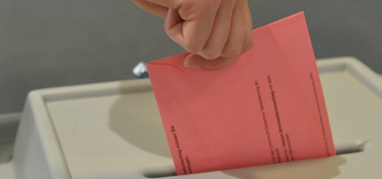 Welche Themen haben einen Einfluss auf die Wahlentscheidung von Studierenden? (Foto: Andreas Meske) Ein Wahlschein wird in die Wahlurne im Wahllokal eingeschmissen.