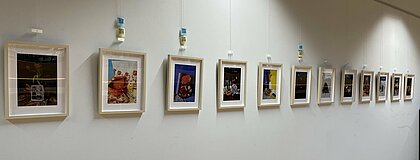 Ausstellung "Mein Zuhause ist.." Man sieht die Bilder, die in einer Ausstellung in der Bibliothek der Hochschule Düsseldorf hängen