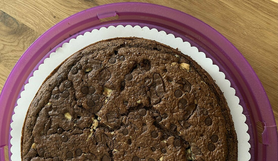 Auf dem Bild sieht man einen runden Brownies, der auf einem Tisch liegt (Foto: Lena Sorgalla)