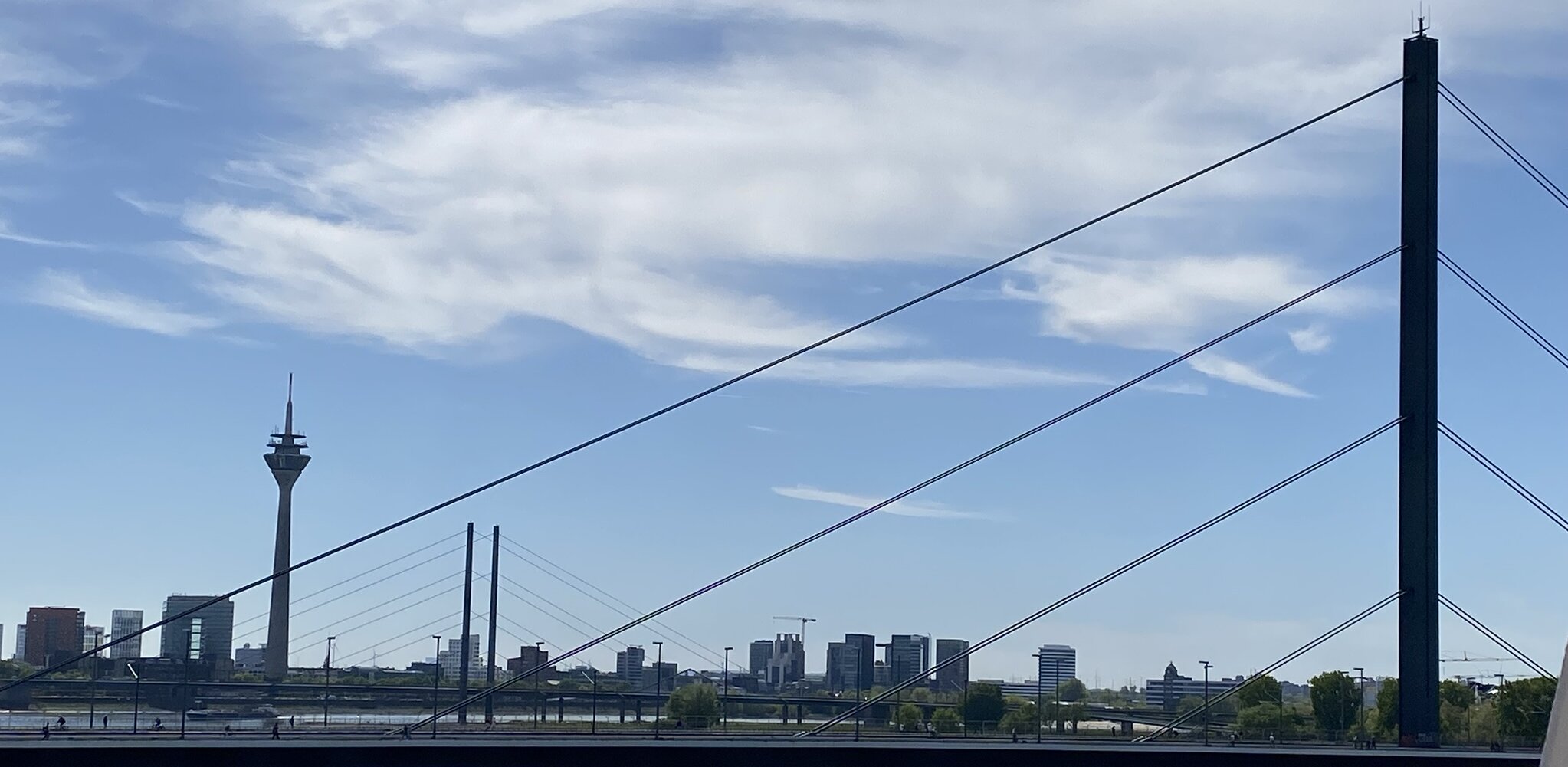 Auf dem Bild sieht man die Skyline von Düsseldorf bei Tag mit der Rheinkniebrücke und dem Fernsehturm