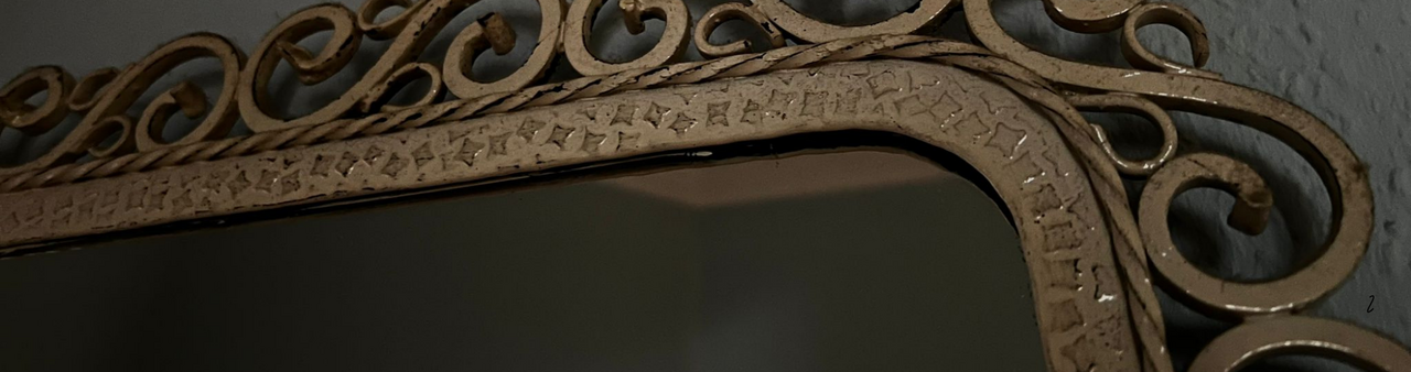 Auf dem Bild sieht man die Ecke eines alten Spiegels mit goldenem Rahmen. An der Seite ist ein Halloween-Logo (Foto: Gregory Sheftel)