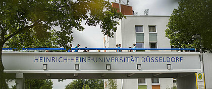 Zu sehen sind Studierende auf einer Fußgängerbrücke des Campus