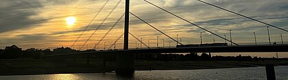 Man sieht die Oberkasseler Brücke beim Sonnenuntergang