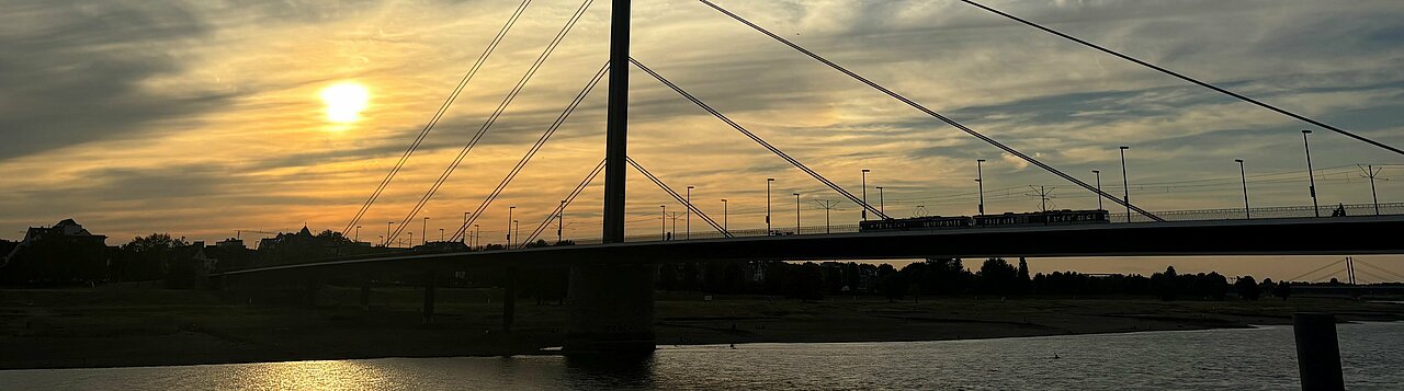 Man sieht die Oberkasseler Brücke beim Sonnenuntergang