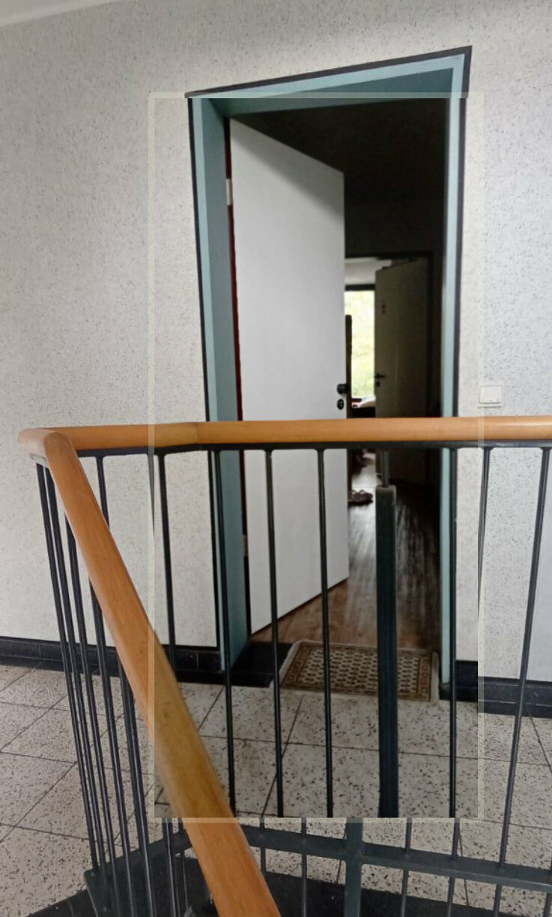 Aus einem Flur blickt man in das innere einer Wohnung in welcher viele Türen geöffnet sind.