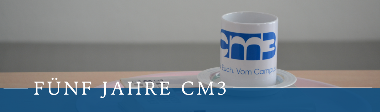 Auf dem Foto sieht man ein Buch und darauf die cm3 Tasse